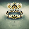 Two gold rings with intricate designs on a reflective surface, featuring the brand 'Valeriy Gromov'.