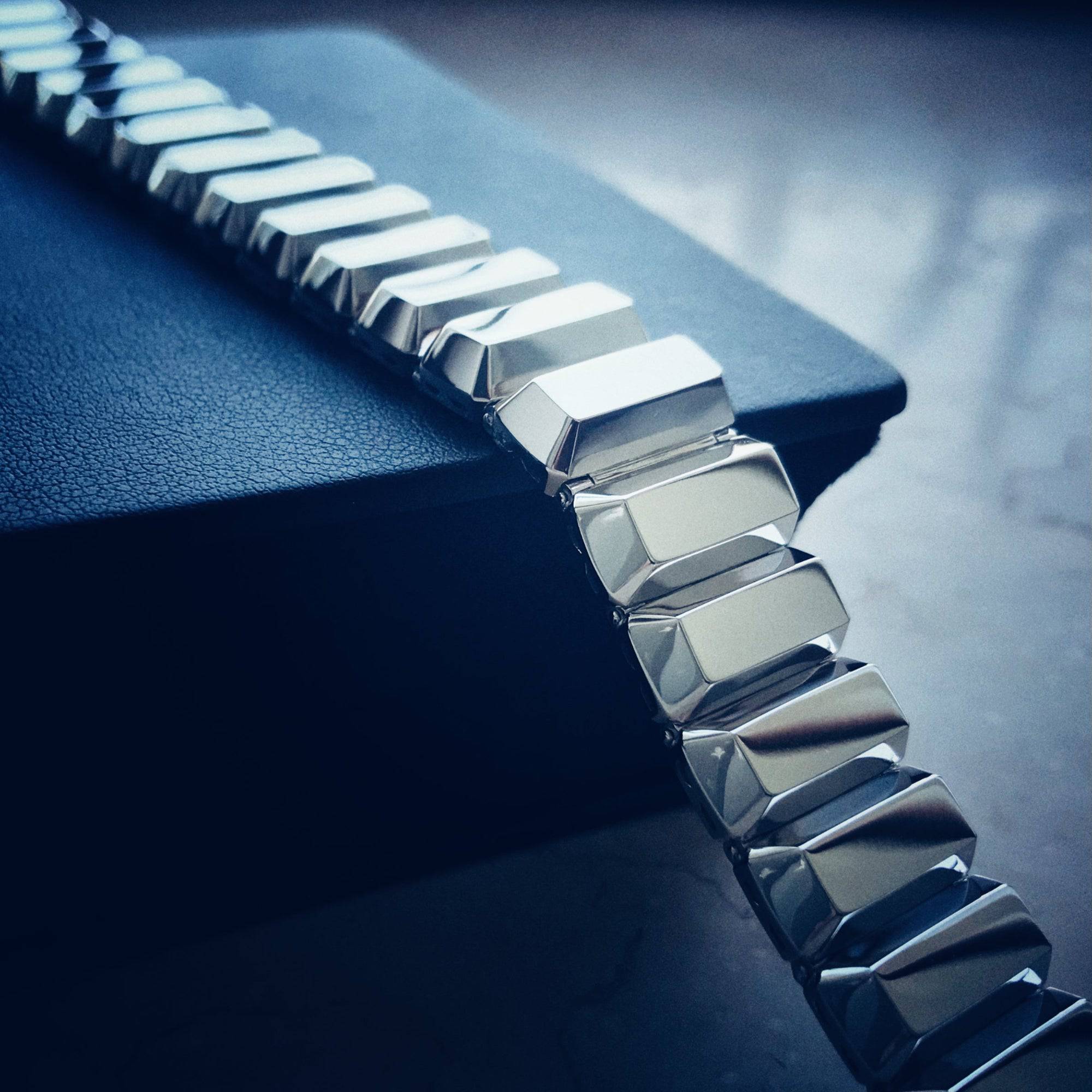 Close-up of a silver bracelet on a dark blue surface