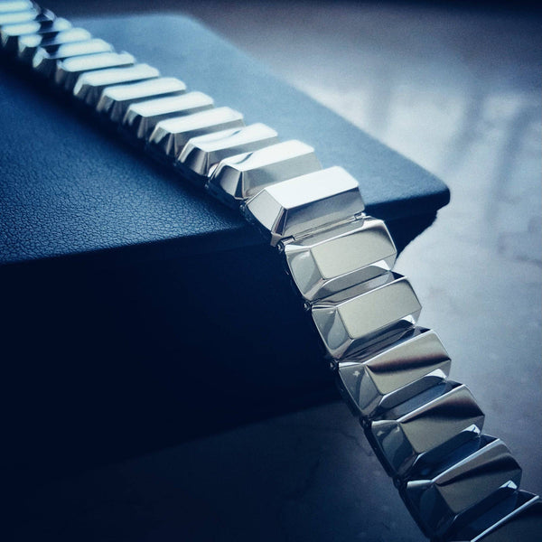 Close-up of a silver bracelet on a dark blue surface