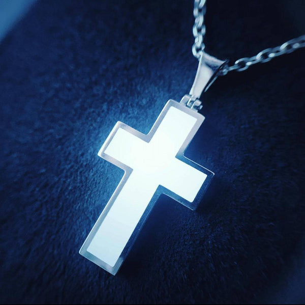 Glowing cross pendant on a dark background